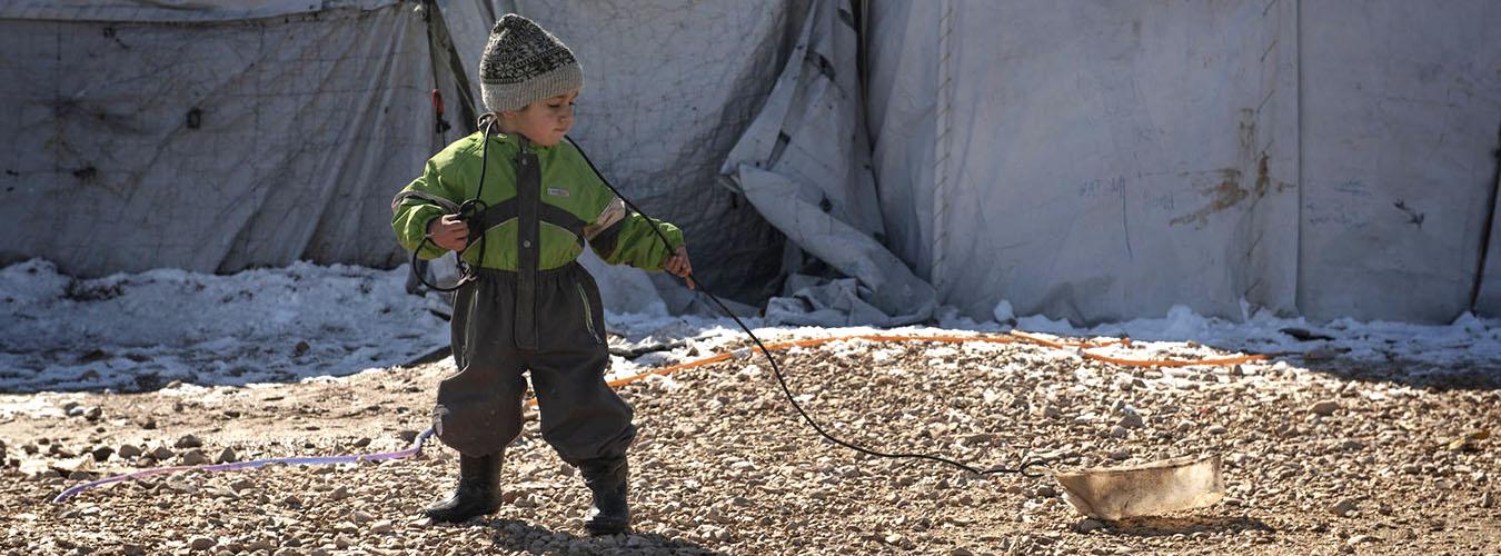 Un niño juega con un trineo casero hecho con un contenedor vacío y un cable, en Roj Camp, en el noreste de Siria (febrero de 2020).